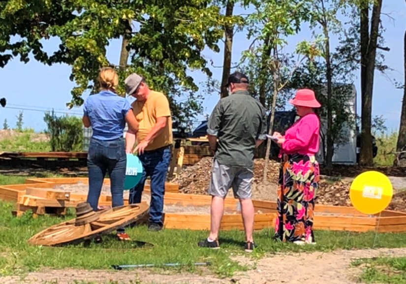 Kingston artist Portia "Po" Chapman meeting with the Sensory Garden design and art installation team on site discussing the sample signs during the playground's construction phase.