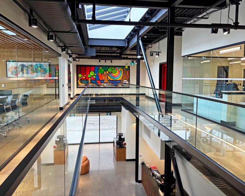 Architectural overview of the "Strong and Growing Stronger" mural at Strong Enterprises HQ, showing its high visibility across the long second-floor mezzanine.