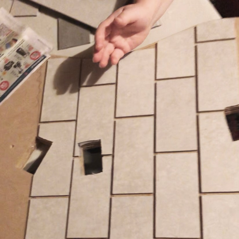 Top-down view of hand-cut stone-hybrid subway tiles being glued in a running bond pattern onto a curved wood plinth surface with pre-cut mortise slots.